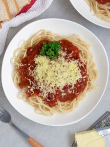 ### Corned Beef Spaghetti Recipe **Corned Beef Spaghetti** is a delightful twist on the classic Filipino-style spaghetti, which is typically known for its sweet and savory sauce. This dish combines the hearty richness of corned beef with a slightly tangy, flavorful tomato sauce, making it a simple yet satisfying meal. It's a comfort food that's easy to prepare and perfect for busy days, family dinners, or even casual get-togethers. In the Philippines, corned beef is a staple in many households, often served with rice or made into various dishes like corned beef hash, sandwiches, or omelets. However, this corned beef spaghetti recipe adds a unique spin by using the canned meat as the base for the sauce. The result is a deliciously savory pasta dish with an added depth of flavor, making it a great alternative to the more traditional spaghetti dishes. --- ### **Ingredients** - **300g spaghetti noodles** (preferably al dente) - **1 can (200g) corned beef** (preferably the chunky variety) - **2 tablespoons vegetable oil** - **1 medium onion**, finely chopped - **4 cloves garlic**, minced - **1 large tomato**, diced - **1/2 cup tomato sauce** (or ketchup, if you prefer a sweeter sauce) - **1 tablespoon soy sauce** (adds a savory depth) - **1/2 teaspoon salt** (to taste) - **1/4 teaspoon pepper** (to taste) - **1/4 cup water** (or beef broth for more flavor) - **1/4 cup grated cheese** (cheddar or quickmelt, for garnish) - **1 tablespoon sugar** (optional, if you prefer a touch of sweetness) - **1 tablespoon butter** (optional, for a richer sauce) - **Chopped parsley or basil** (for garnish) --- ### **Instructions** #### **1. Cook the Spaghetti** Start by cooking the spaghetti according to the package instructions. Bring a large pot of salted water to a boil, then add the spaghetti. Stir occasionally to prevent the noodles from sticking together. Once cooked al dente (usually about 8-10 minutes), drain the pasta and set it aside. You can toss it with a little olive oil to prevent sticking if you're not immediately using it in the sauce. #### **2. Prepare the Corned Beef Sauce** While the spaghetti is cooking, heat the vegetable oil in a large skillet or pan over medium heat. Add the finely chopped onions and sauté until they become translucent and fragrant—this usually takes about 2-3 minutes. Then, add the minced garlic and cook for another 30 seconds until it’s golden and aromatic. #### **3. Add the Tomatoes** Add the diced tomato to the pan and cook it down for about 5 minutes, or until the tomato softens and begins to break down. This helps to create a fresh base for the sauce. #### **4. Incorporate the Corned Beef** Next, add the canned corned beef into the pan, breaking it up with a spoon or spatula to mix it well with the onions and tomatoes. Stir-fry for about 3-4 minutes, allowing the flavors to meld together. The corned beef will release its natural fats and flavors, which will blend with the other ingredients. #### **5. Add the Sauces and Seasonings** Pour in the tomato sauce (or ketchup), soy sauce, salt, pepper, and water (or beef broth) into the pan. Stir everything together to combine, then let it simmer on low heat for about 5-7 minutes. You can adjust the amount of water if you want a thinner or thicker sauce. If you like your sauce on the sweeter side, feel free to add a tablespoon of sugar to balance out the acidity of the tomatoes. #### **6. Combine with the Spaghetti** Once the corned beef sauce is ready, it’s time to combine it with the cooked spaghetti. Add the drained pasta directly into the pan with the corned beef mixture. Gently toss the pasta in the sauce, making sure the noodles are well-coated with the rich, savory mixture. Let it cook together for another 2-3 minutes, so the pasta can absorb some of the flavors from the sauce. #### **7. Finish with Cheese and Butter** For an extra layer of richness, you can stir in a tablespoon of butter into the sauce just before serving. It will give the sauce a velvety texture and enhance the flavor. Once well-mixed, transfer the spaghetti to a serving dish. Garnish with freshly grated cheese on top and a sprinkle of chopped parsley or basil for a pop of color. --- ### **Serving Suggestions** Corned Beef Spaghetti is best served hot, and it’s a great dish to enjoy on its own or paired with a simple side salad or garlic bread. The savory flavors of the corned beef blend beautifully with the tomato-based sauce, while the pasta offers the perfect vehicle for all those rich and comforting flavors. For an added touch of indulgence, you can serve it with extra cheese on top or drizzle some extra tomato sauce or ketchup if you prefer a slightly sweeter taste. If you have kids or guests who prefer more familiar flavors, this dish is sure to be a hit! --- ### **Tips and Variations** 1. **Vegetables:** You can add diced carrots, bell peppers, or peas to the corned beef sauce to introduce extra flavor and nutrition. These vegetables complement the savory taste of the corned beef and add color and texture to the dish. 2. **Spicy Kick:** If you love a bit of heat, add a pinch of chili flakes or sliced fresh chili to the corned beef sauce. The heat balances well with the rich, salty flavor of the corned beef. 3. **Creamy Version:** For a creamier texture, stir in a few tablespoons of cream or a dollop of mayonnaise. This will make the sauce smoother and add a touch of indulgence. 4. **Leftover Meat:** If you have leftover cooked meat such as roast beef, pork, or chicken, feel free to substitute it for the corned beef. It’s a great way to use up leftovers and create a unique version of the dish. 5. **Vegetarian Option:** If you're looking for a vegetarian version of this dish, you can replace the corned beef with vegetarian or plant-based alternatives, such as lentils or tofu. You can also make the dish without meat and add more vegetables for a lighter version. --- ### **Why You’ll Love This Corned Beef Spaghetti** - **Quick and Easy:** This is a simple, no-fuss recipe that doesn’t require a lot of time or ingredients. It's perfect for busy weekdays or when you need to whip up a meal in a hurry. - **Comforting:** The savory corned beef and rich tomato sauce create a warm, hearty meal that will satisfy your cravings. - **Customizable:** You can adjust the flavors to suit your taste—whether you prefer it sweet, tangy, or spicy, this dish can be made to your liking. - **Family-Friendly:** Corned Beef Spaghetti is a crowd-pleaser that both adults and children will enjoy, making it a great choice for family dinners or parties. --- Corned Beef Spaghetti is a delicious fusion of Filipino comfort food with a modern twist. The combination of savory corned beef and tangy tomato sauce, paired with perfectly cooked pasta, creates a dish that’s satisfying and flavorful. It’s easy to make, customizable, and sure to become a household favorite in no time! 